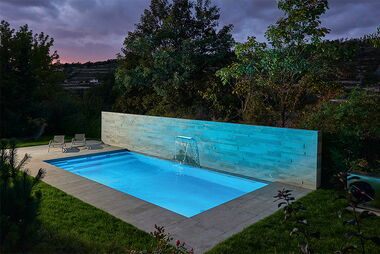 Ein Pool, welcher mit blauen Lampen beleuchtet wird.